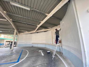 Un operari pinta la paret de l'aparcament de Lepanto.