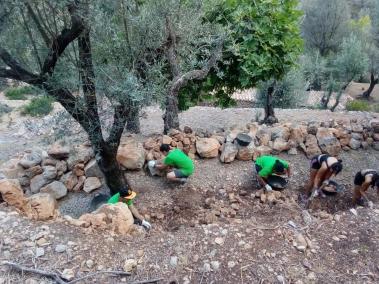 Els voluntaris decanten les pedres dels marges caiguts.