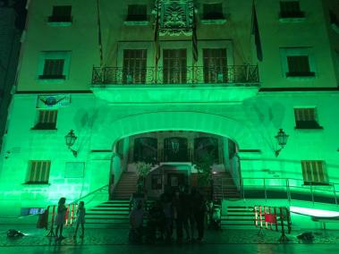 La façana de l'Ajuntament es tenyeix de color verd per visibilitzar les malalties mitocondrials