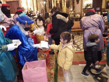 Una nineta lliurant la seva carta a un dels patges reials.