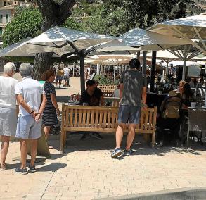 Una parella de turistes llegeix la carta d’un restaurant de primera línea del Port.