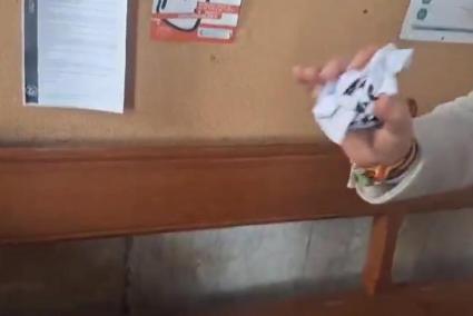 Fotograma del vídeo en el qual el conseller neofeixista de VOX llança a les escombraries un cartell de l'escola en català.