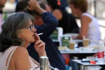 Persones fumant a una terrassa.