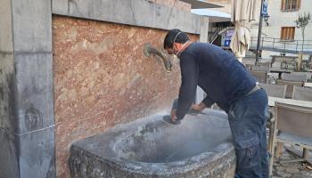 Un operari neteja la calç de la pedra.