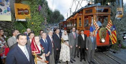 Personalitats i autoritats convidades als actes, davant el tramvia engalanat amb banderes.