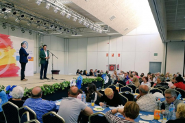 Company, davant una gran bandera espanyola amb les sigles del PP, durant el dinar dels populars de Calvià.