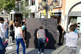 Dins la capsa negra, l'artista, armada de làmpades, guants, papers i un rellotge, desenvolupa el seu espectacle.