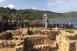 Desenes de persones participen en una visita arqueològica a Cabrera.