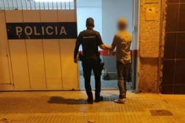 Un agent policial al costat del detingut.