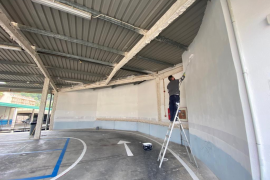 Un operari pinta la paret de l'aparcament de Lepanto.
