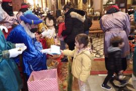 Una nineta lliurant la seva carta a un dels patges reials.