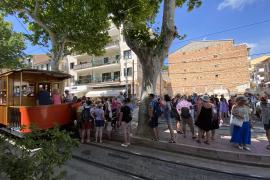 Un gran nombre de turistes esperen a l’aturada del tramvia, al Port.