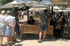 Una parella de turistes llegeix la carta d’un restaurant de primera línea del Port.