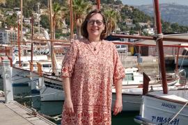 Antònia López al moll comercial del Port de Sóller rodejada de llaüts i la mar.