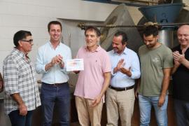 El president del Consell de Mallorca, Llorenç Galmés, ha lliurat el distintiu a Tomeu Deyà, propietari de la tafona històrica que manté viu el sistema tradicional de producció, en reconeixement al seu valor com a símbol del paisatge agrícola de la Serra de Tramuntana