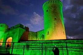 Espectaculars imatges del castell de Bellver il·luminat de verd per l’artritis
