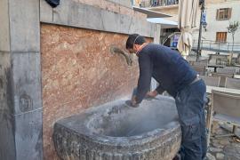 Un operari neteja la calç de la pedra.