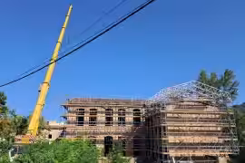 Una gran grua ajuda amb les tasques de col·locació de la sobrecoberta.